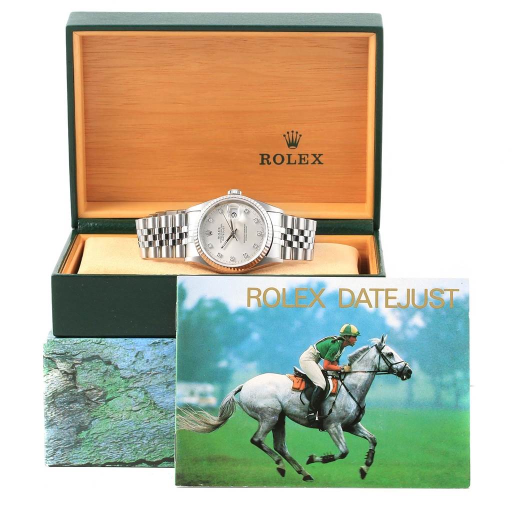 The Rolex Datejust 16234 Stainless Steel Silver Dial 16234 Stainless Steel Silver Dial watch is displayed front-facing inside an open green and wood box, along with its brochure in front.