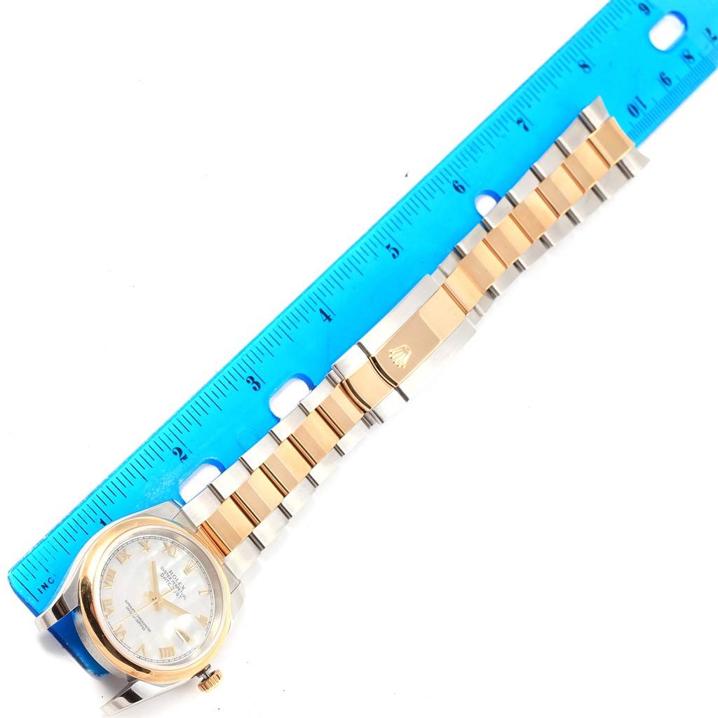 The image shows a Rolex Datejust 116203 Stainless Steel Mother of Pearl Dial 116203 Stainless Steel Mother of Pearl Dial watch laid flat next to a blue ruler, displaying its face and two-tone metal bracelet.