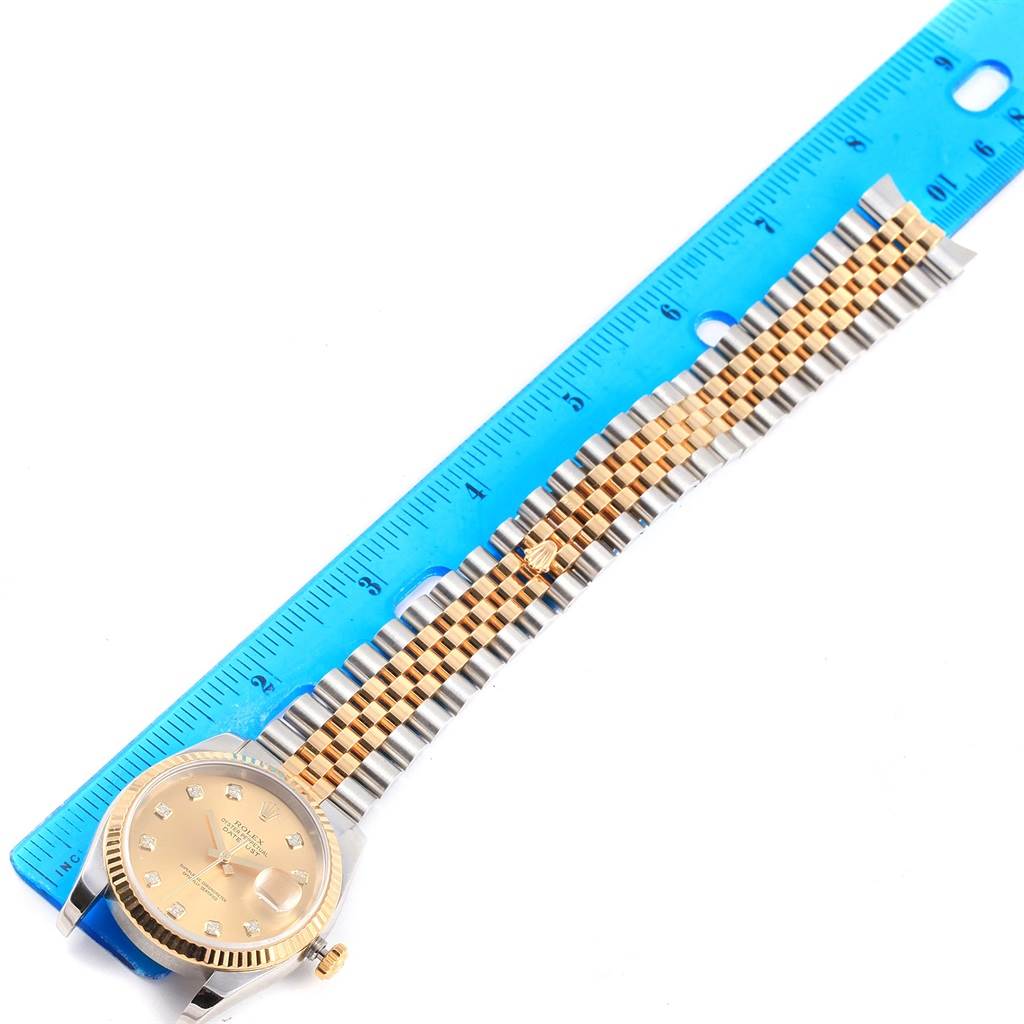 The image shows a Rolex Datejust 116233 Stainless Steel Champagne Dial 116233 Stainless Steel Champagne Dial watch laid flat next to a blue ruler, displaying the dial and bracelet.