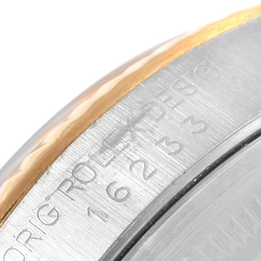 This close-up image of a Rolex Datejust 16233 Steel and Gold (two tone) Champagne Dial 16233 Steel and Gold (two tone) Champagne Dial watch shows part of the case and the edge of the bezel with engravings.