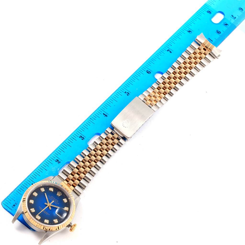 The Rolex Datejust 16233 Steel and Gold (two tone) Blue Dial 16233 Steel and Gold (two tone) Blue Dial watch, featuring its face, bezel, and bracelet, is displayed flat with a ruler for scale.