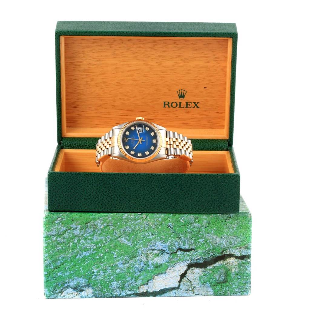The Rolex Datejust 16233 Steel and Gold (two tone) Blue Dial 16233 Steel and Gold (two tone) Blue Dial watch is displayed front-facing, inside an open green and wood-toned Rolex box.