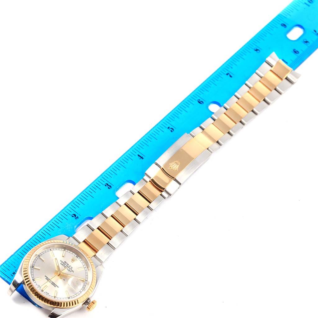 The image shows a Rolex Datejust 116233 Men's Stainless Steel Silver Dial 116233 Men's Stainless Steel Silver Dial watch laid flat next to a ruler, displaying the face, bezel, and full bracelet.