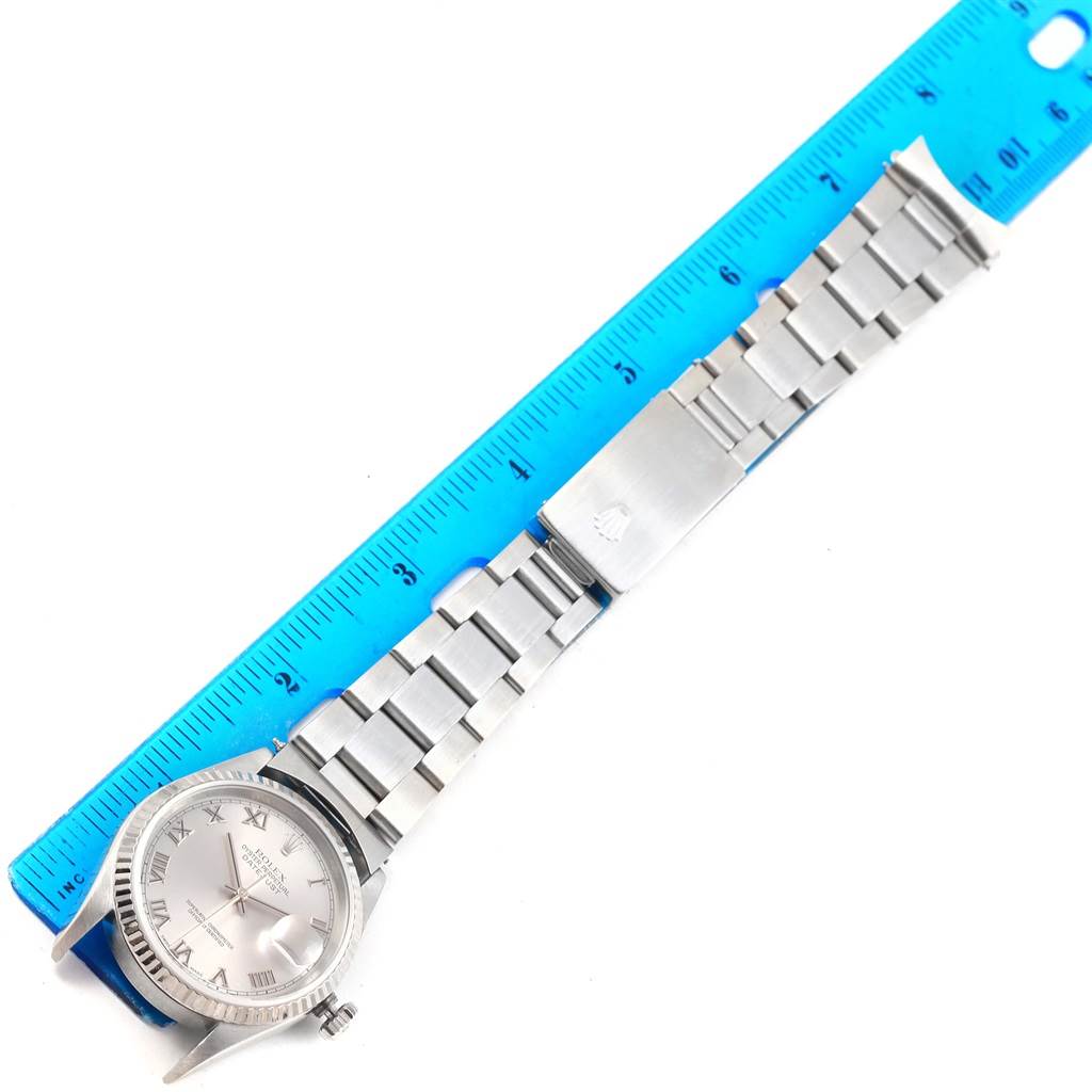 The Rolex Datejust 16234 Men's Stainless Steel Silver Dial 16234 Men's Stainless Steel Silver Dial watch is shown laid flat with its face, bezel, and bracelet visible next to a ruler for measurement.