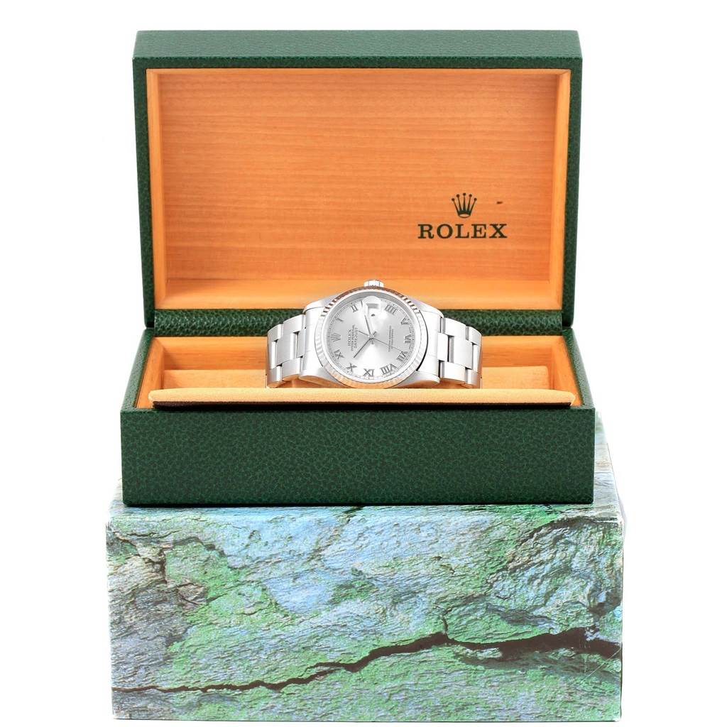 The Rolex Datejust 16234 Men's Stainless Steel Silver Dial 16234 Men's Stainless Steel Silver Dial watch is displayed frontally inside an open green and orange box with the Rolex logo.