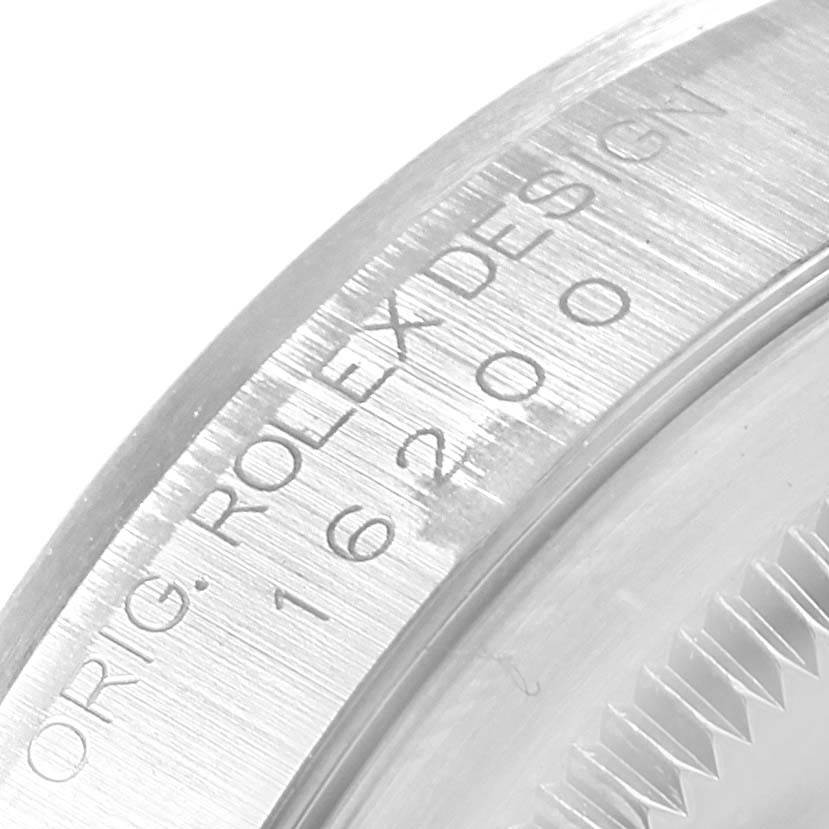The image shows a close-up of the Rolex Datejust 16200 Men's Stainless Steel Silver Dial 16200 Men's Stainless Steel Silver Dial model watch case with "ORIG. ROLEX DESIGN" and model number engraving.