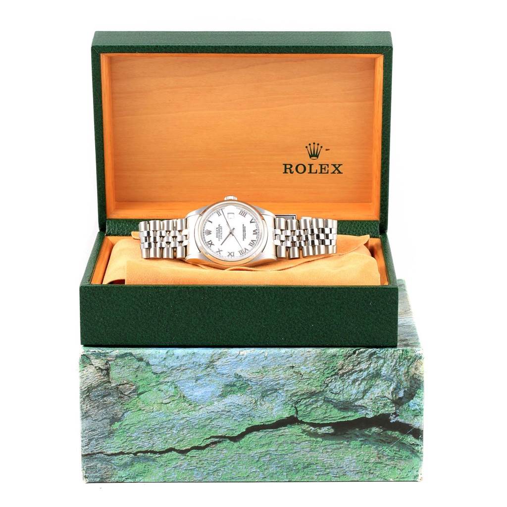 The Rolex Datejust 16200 Men's Stainless Steel White Dial 16200 Men's Stainless Steel White Dial watch is shown from the front inside its green and wood presentation box, resting on an orange cushion.