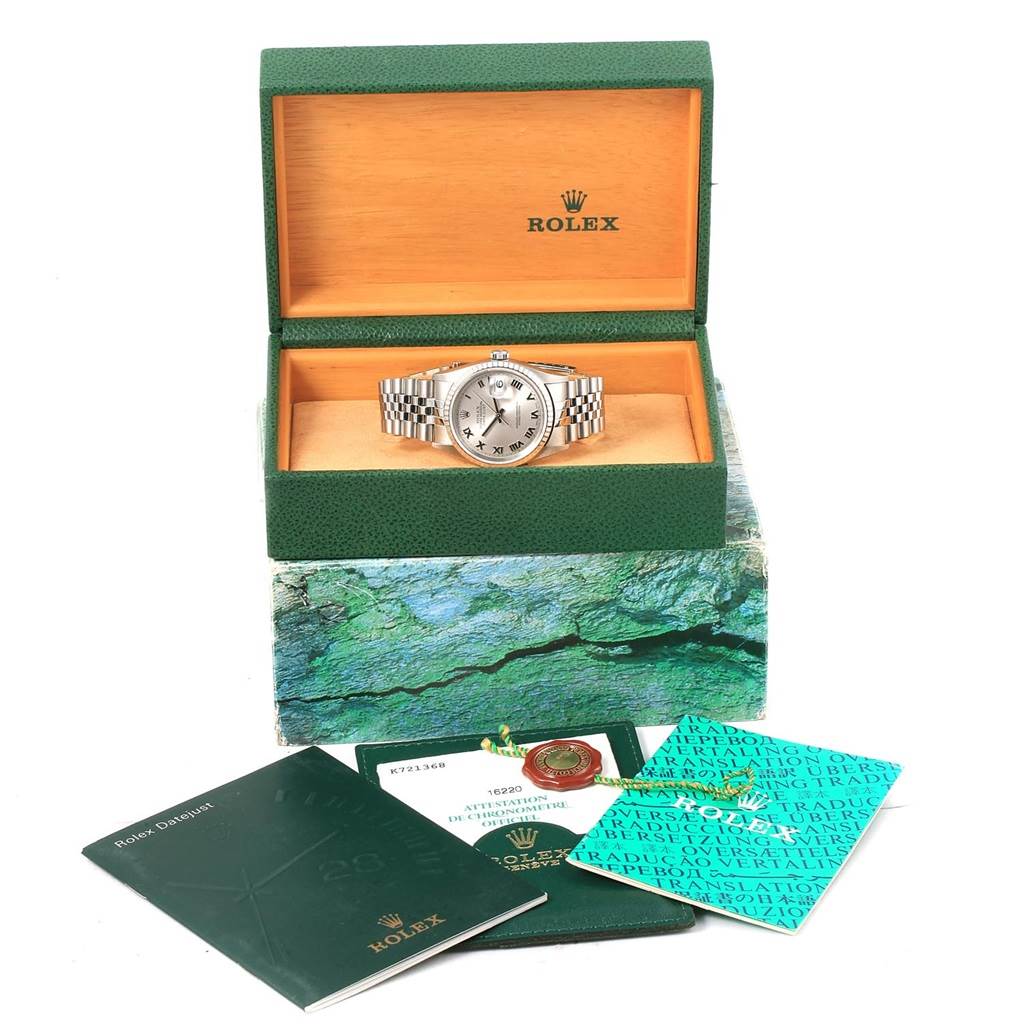 The Rolex Datejust 16220 Men's Stainless Steel Silver Dial 16220 Men's Stainless Steel Silver Dial watch is shown from the front, in its open box with accessories, booklets, and a tag displayed.