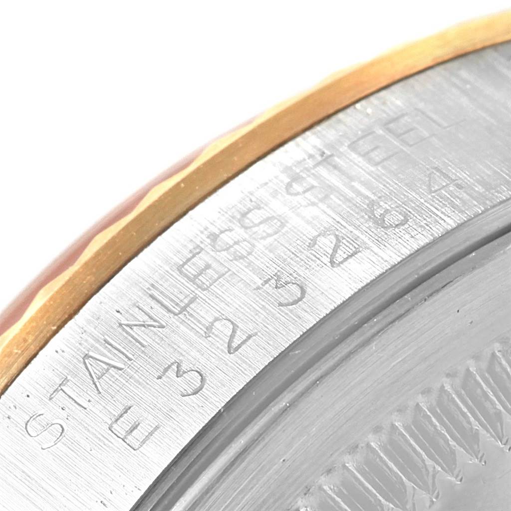 This image shows a close-up angle of the bezel and part of the case of a Rolex Datejust 16233 Men's Steel and Gold (two tone) Black Dial 16233 Men's Steel and Gold (two tone) Black Dial watch, highlighting the stainless steel engraving.