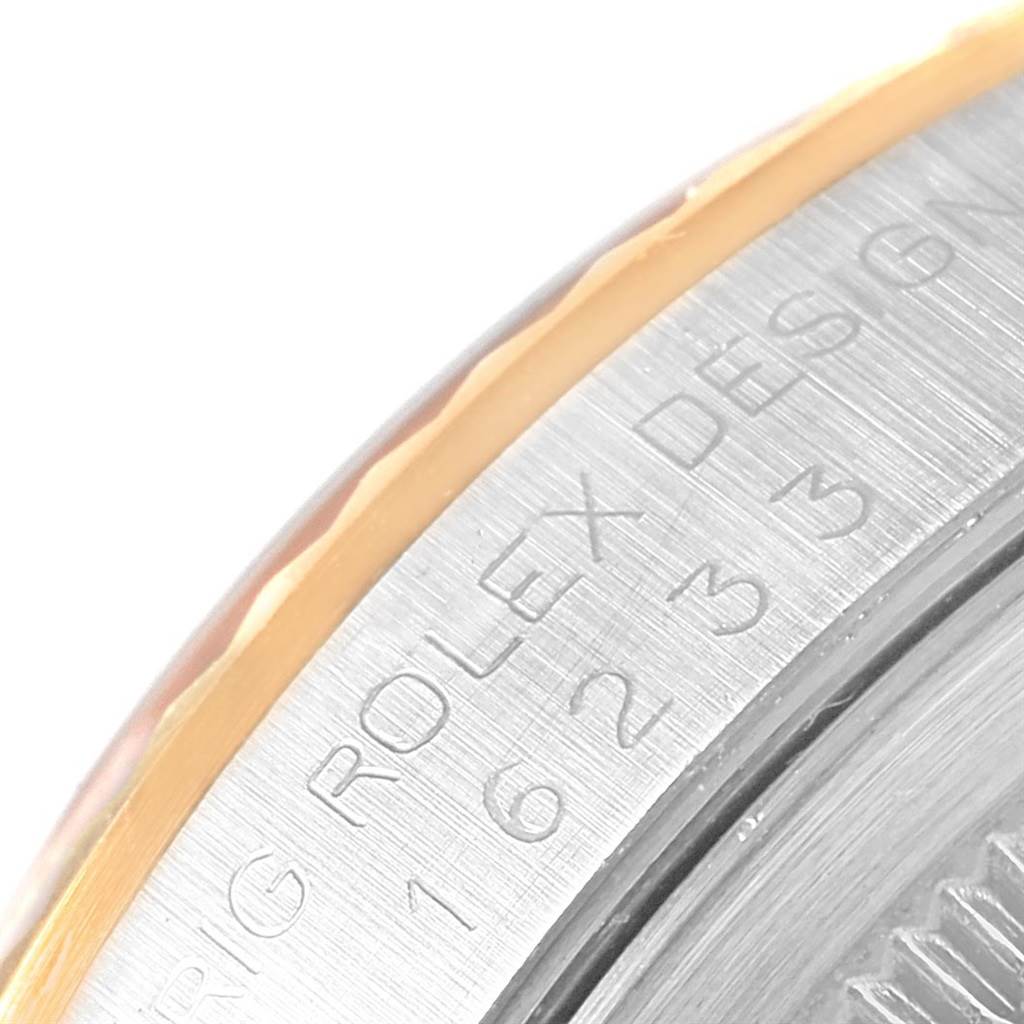This close-up image shows the engraved side of the case of a Rolex Datejust 16233 Men's Steel and Gold (two tone) Black Dial 16233 Men's Steel and Gold (two tone) Black Dial watch.
