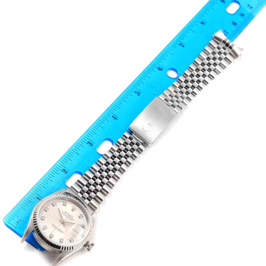 The image shows a Rolex Datejust 16234 Men's Stainless Steel Silver Dial 16234 Men's Stainless Steel Silver Dial watch laid flat along a blue ruler, displaying the watch face, case, and Jubilee bracelet.