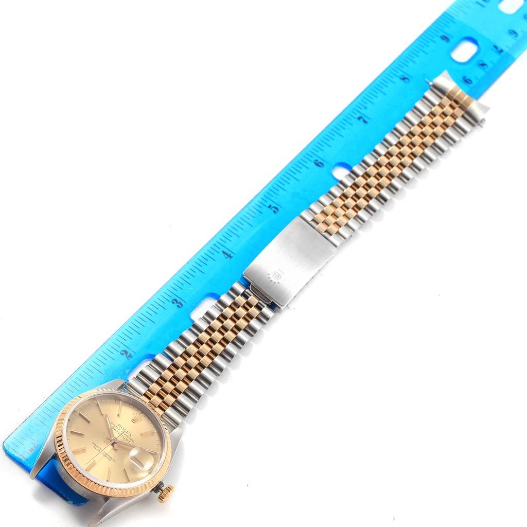 This image shows a Rolex Datejust 16233 Men's Steel and Gold (two tone) Champagne Dial 16233 Men's Steel and Gold (two tone) Champagne Dial watch lying flat, with its full bracelet alongside a measuring ruler.