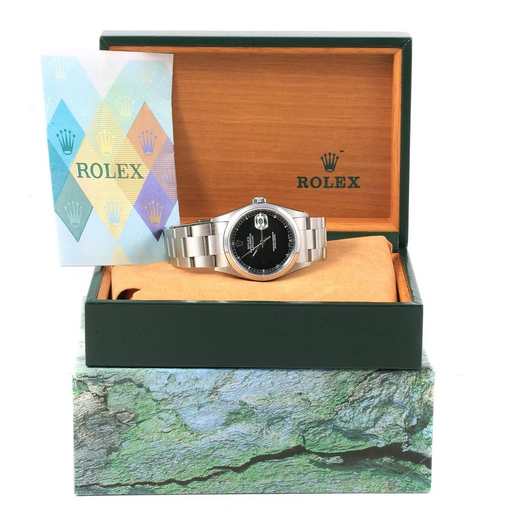 The image shows a front view of a Rolex Datejust 16200 Men's Stainless Steel Black Dial 16200 Men's Stainless Steel Black Dial watch in an open box with a booklet on the left side.