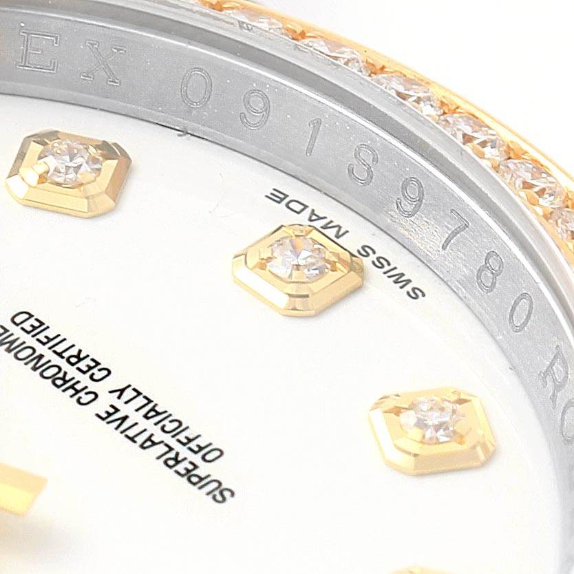 This close-up of the Rolex Datejust 116243 Stainless Steel White Dial 116243 Stainless Steel White Dial watch shows part of the dial with diamond markers and the engraved model number on the bezel.