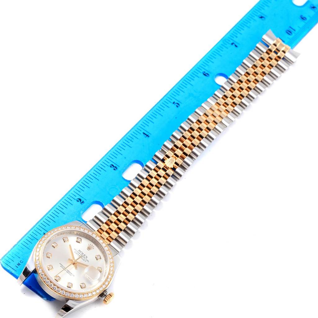 This image shows a top-down view of a Rolex Datejust 116243 Stainless Steel Silver Dial 116243 Stainless Steel Silver Dial watch, highlighting its face, case, and bracelet with a blue ruler for measurement.