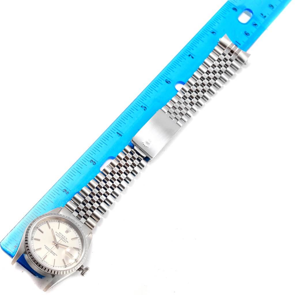 The image shows a Rolex Datejust 16220 Men's Stainless Steel Silver Dial 16220 Men's Stainless Steel Silver Dial watch laid out flat with a blue ruler beside it, highlighting the watch head and bracelet.