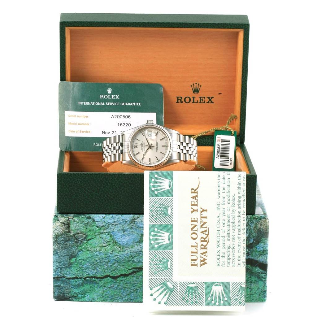 The Rolex Datejust 16220 Men's Stainless Steel Silver Dial 16220 Men's Stainless Steel Silver Dial watch is shown front-on in its open box with warranty and service guarantee cards visible.