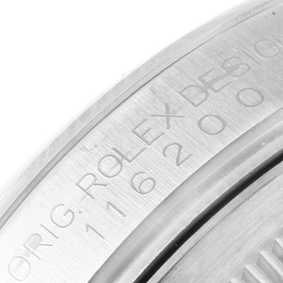 The image shows an angled close-up of the caseback edge of the Rolex Datejust 116200 Men's Stainless Steel Blue Dial 116200 Men's Stainless Steel Blue Dial watch, highlighting engraved text.