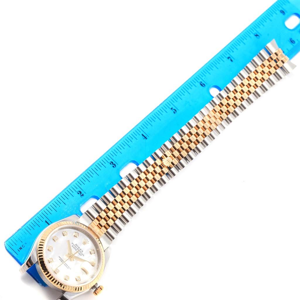 The image shows the face and bracelet of a Rolex Datejust 116233 Men's Stainless Steel Mother of Pearl Dial 116233 Men's Stainless Steel Mother of Pearl Dial watch, aligned with a blue ruler for measurement.