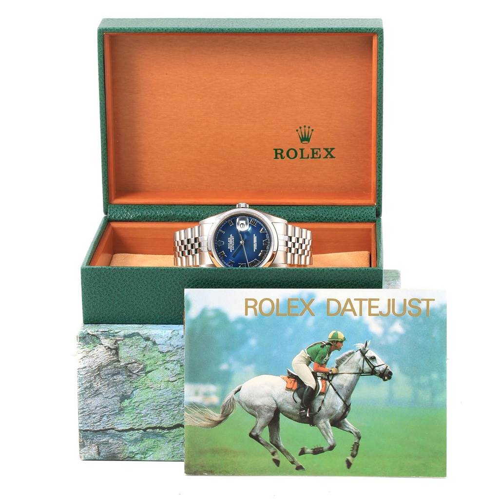 The Rolex Datejust 16200 Men's Stainless Steel Blue Dial 16200 Men's Stainless Steel Blue Dial watch is shown front-on in an open green box with a booklet in front.