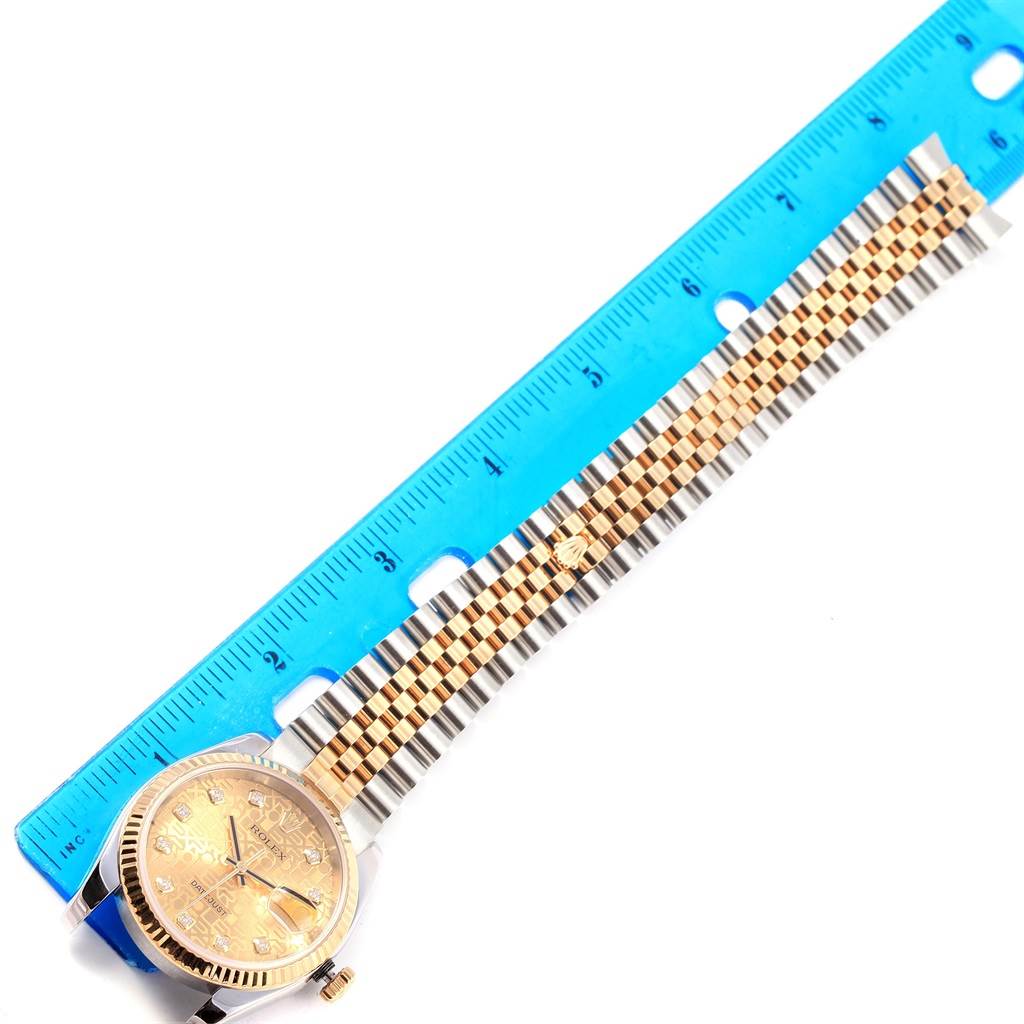 The image shows a Rolex Datejust 116233 Men's Stainless Steel Champagne Dial 116233 Men's Stainless Steel Champagne Dial watch with a gold dial and two-tone bracelet, positioned beside a ruler for scale.