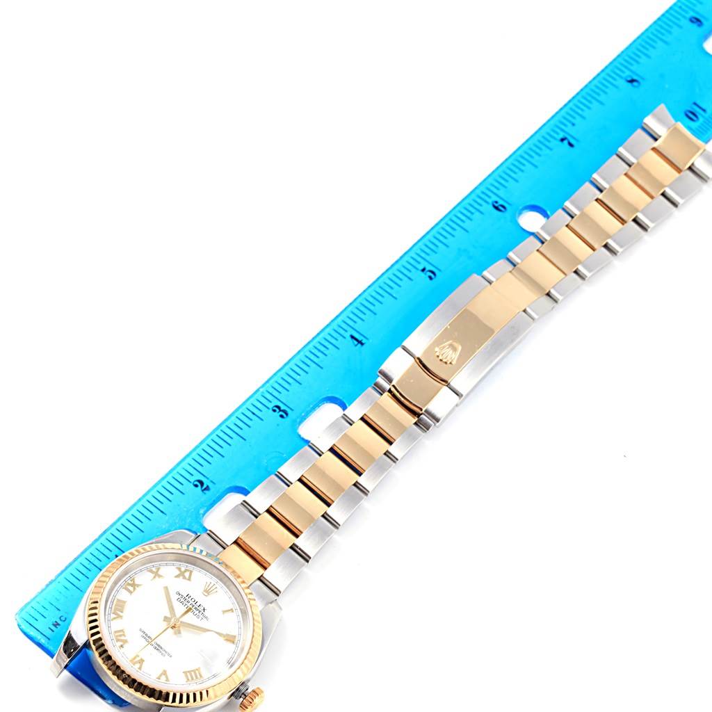 The image displays a Rolex Datejust 116233 Men's Stainless Steel White Dial 116233 Men's Stainless Steel White Dial watch in a horizontal orientation with its bracelet and clasp laid alongside a blue ruler.