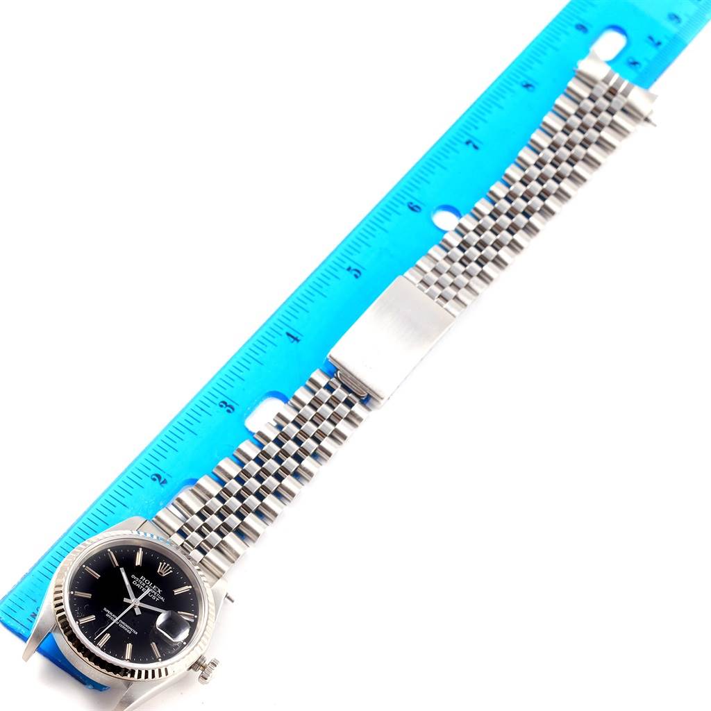 The image shows a top-down view of a Rolex Datejust 16234 Men's Stainless Steel Black Dial 16234 Men's Stainless Steel Black Dial watch laid next to a ruler, displaying the watch face and metal strap.