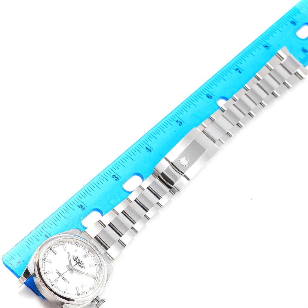 The image shows a Rolex Datejust 116200 Men's Stainless Steel White Dial 116200 Men's Stainless Steel White Dial watch with its bracelet laid out next to a blue ruler for measurement.