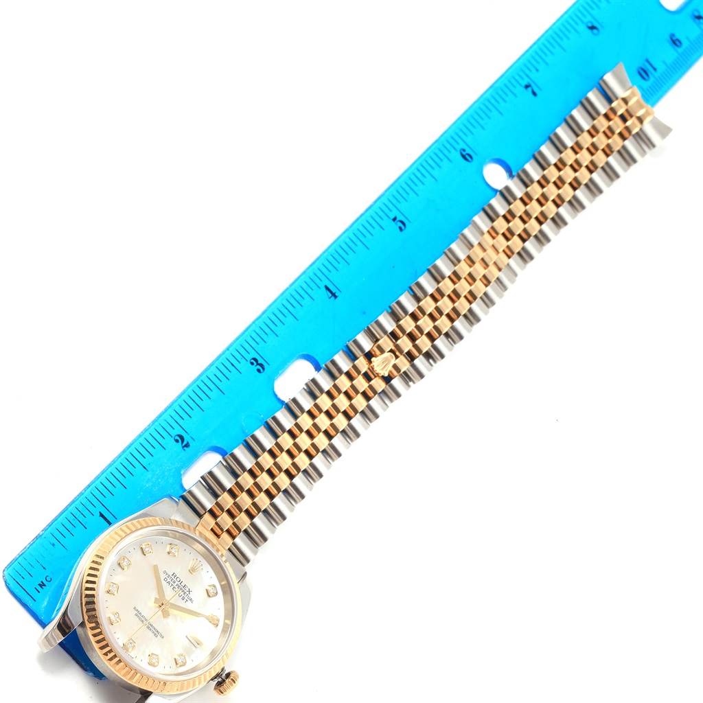 The image shows a Rolex Datejust 116233 Stainless Steel Mother of Pearl Dial 116233 Stainless Steel Mother of Pearl Dial watch from an angled top view, displaying its face and metal bracelet alongside a blue ruler.