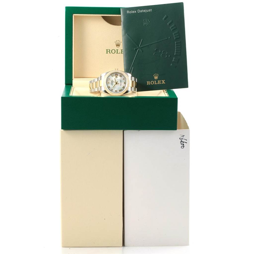 The Rolex Datejust 116243 Men's Stainless Steel Mother of Pearl Dial 116243 Men's Stainless Steel Mother of Pearl Dial watch is displayed in its open box, accompanied by a green booklet.