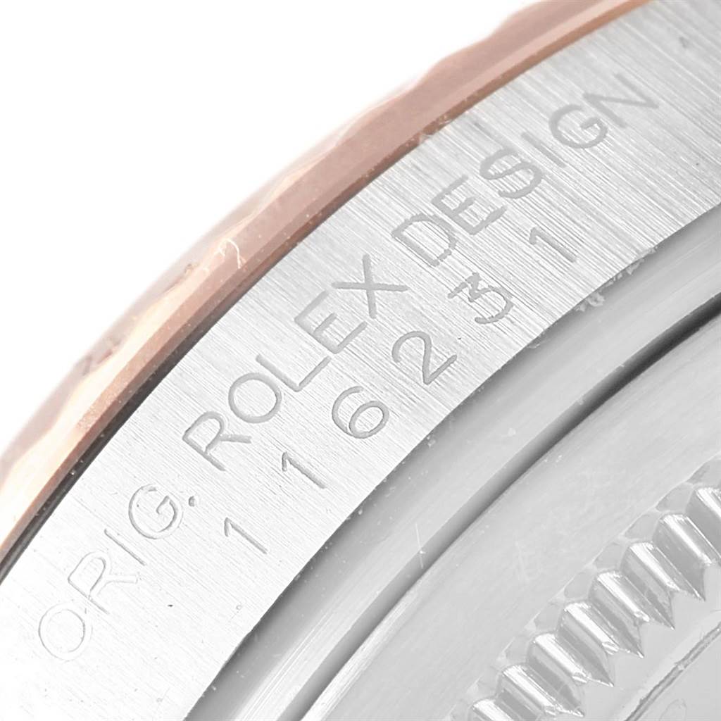 This close-up image shows the engraved edge of the Rolex Datejust 116231 Steel and Gold (two tone) Pink Dial 116231 Steel and Gold (two tone) Pink Dial's case, featuring the model number and "ORIG. ROLEX DESIGN."