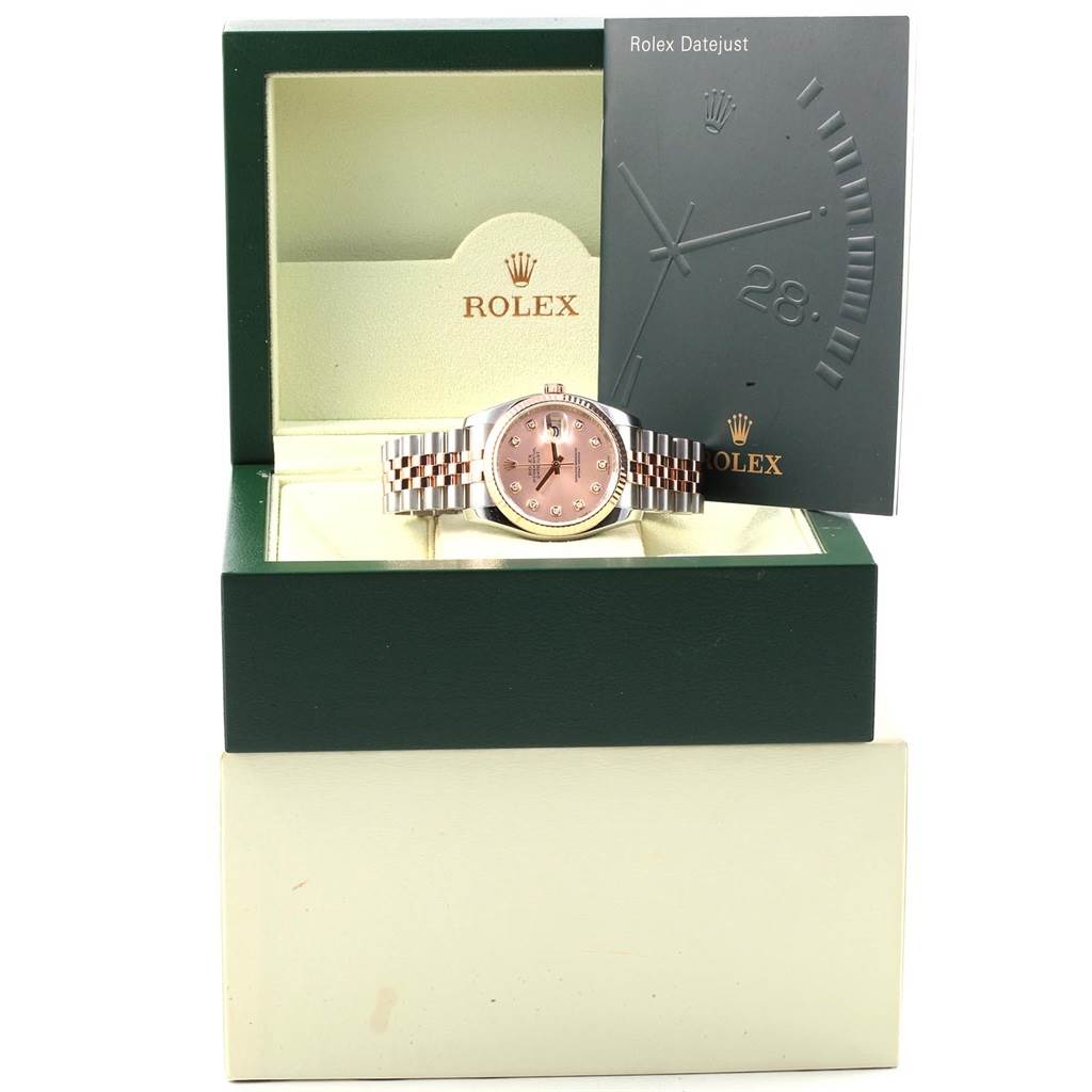 The Rolex Datejust 116231 Steel and Gold (two tone) Pink Dial 116231 Steel and Gold (two tone) Pink Dial watch is displayed in an open box, showing the dial and bracelet, along with accompanying documentation.