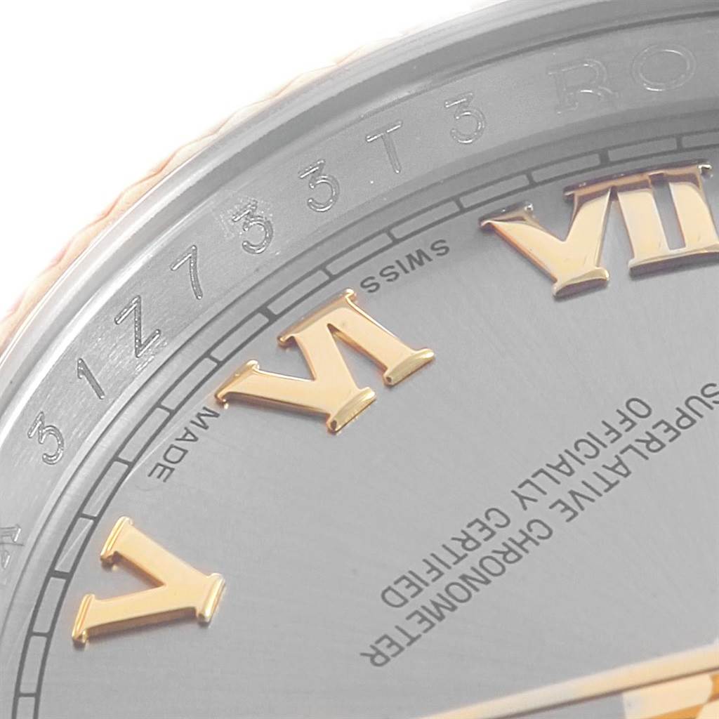 The image captures a close-up angle of the Rolex Datejust 116233 Men's Stainless Steel Silver Dial 116233 Men's Stainless Steel Silver Dial's dial, showcasing part of the Roman numerals and some text.