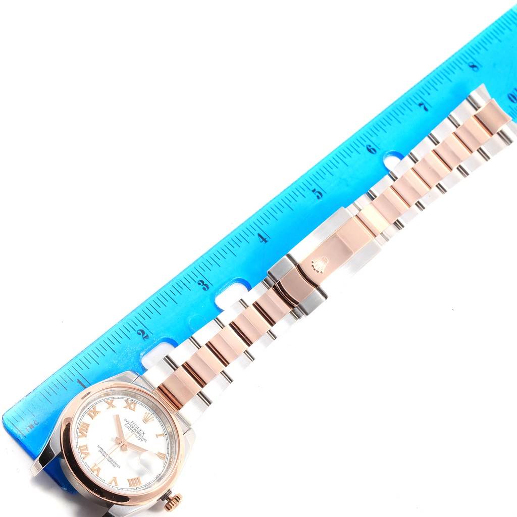 This image shows a Rolex Datejust 116201 Men's Steel and Gold (two tone) White Dial 116201 Men's Steel and Gold (two tone) White Dial watch, including the face and band, measured alongside a blue ruler.