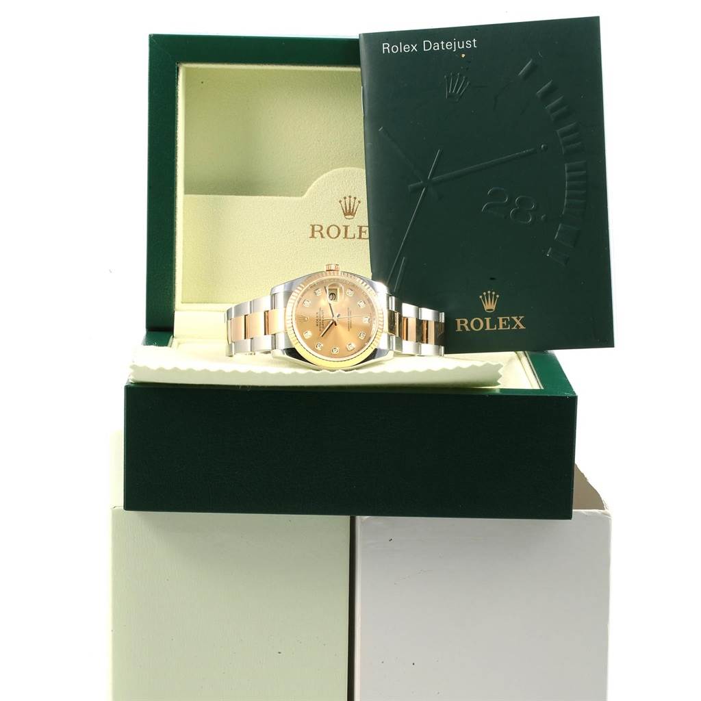 The Rolex Datejust 116233 Men's Stainless Steel Champagne Dial 116233 Men's Stainless Steel Champagne Dial watch is shown at a frontal angle, inside its open box with a booklet propped behind it.