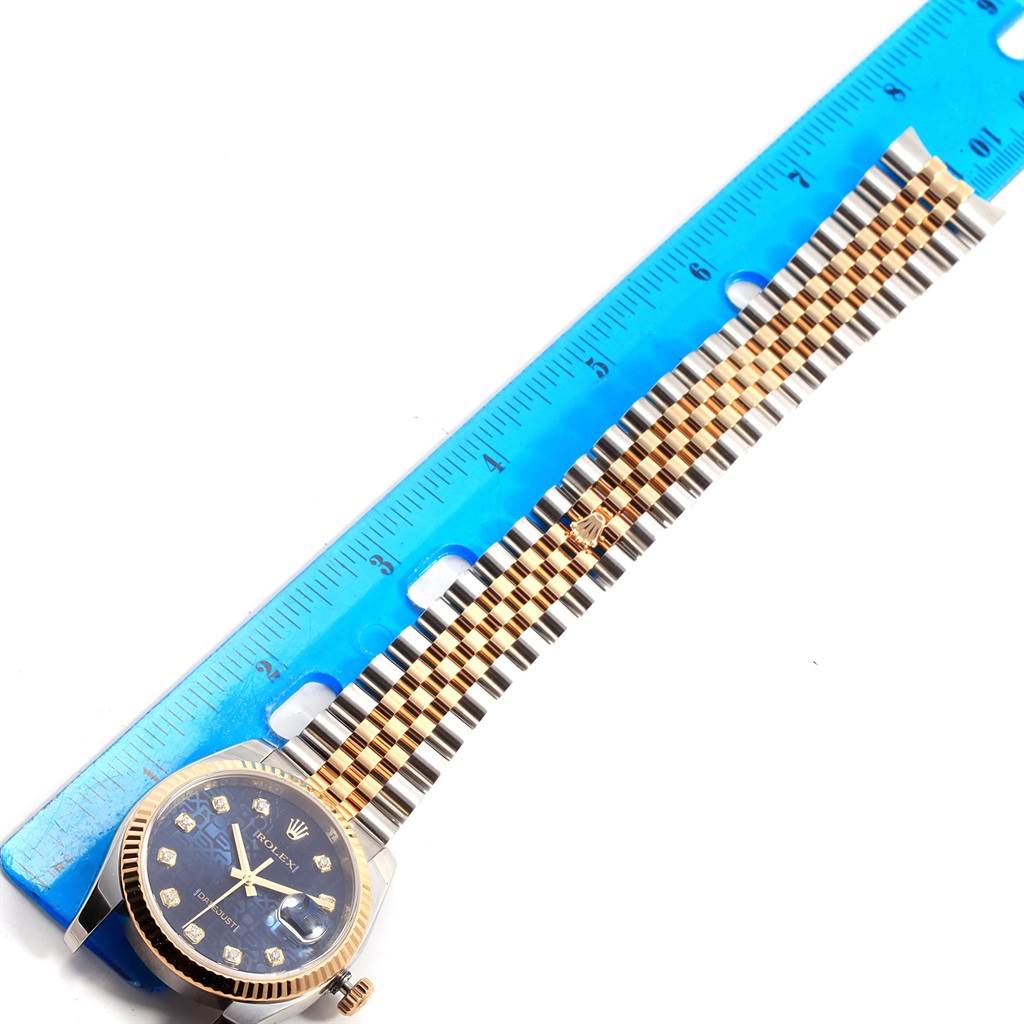 This image shows a Rolex Datejust 116233 Men's Stainless Steel Blue Dial 116233 Men's Stainless Steel Blue Dial watch laid flat alongside a ruler, displaying the face, bezel, and band.