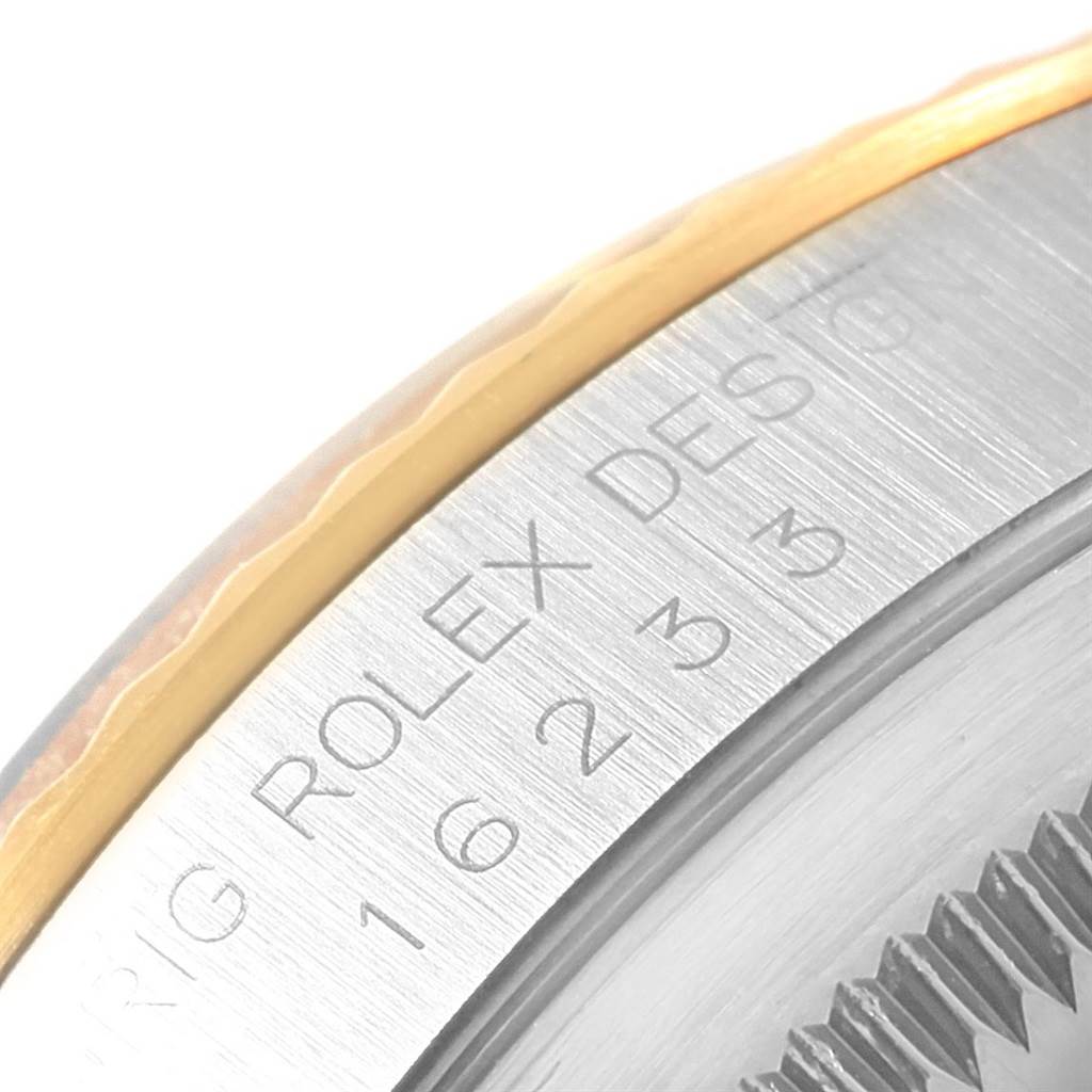 This close-up image shows the side view of a Rolex Datejust 16233 Men's Steel and Gold (two tone) Champagne Dial 16233 Men's Steel and Gold (two tone) Champagne Dial model's bezel and edge of its case, highlighting engraved text.