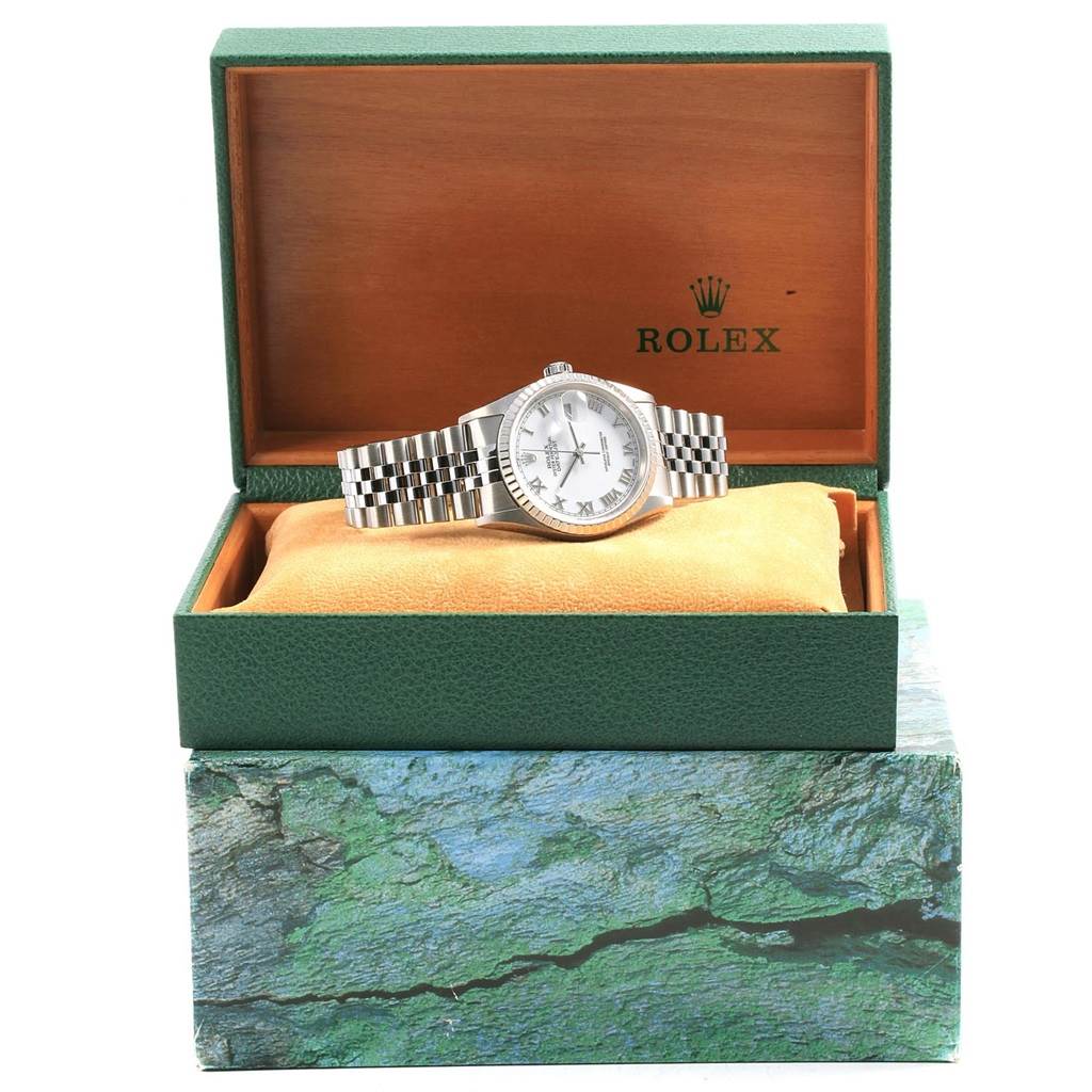 The Rolex Datejust 16220 Men
s Stainless Steel White Dial 16220 Men
s Stainless Steel White Dial watch is displayed front-on in an open green presentation box with a beige cushion.