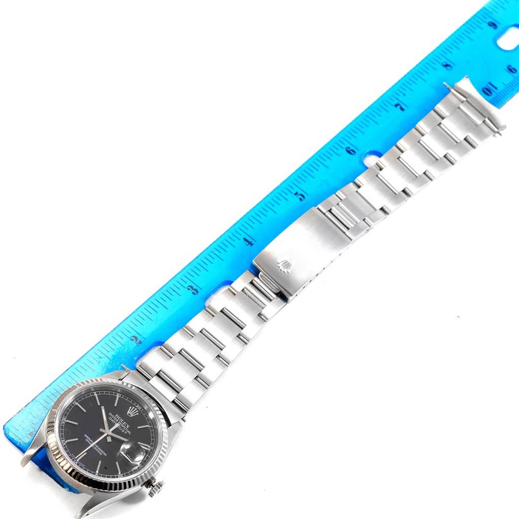 This image shows a Rolex Datejust 16220 Men's Stainless Steel Black Dial 16220 Men's Stainless Steel Black Dial watch laid out flat with a blue ruler for size reference.