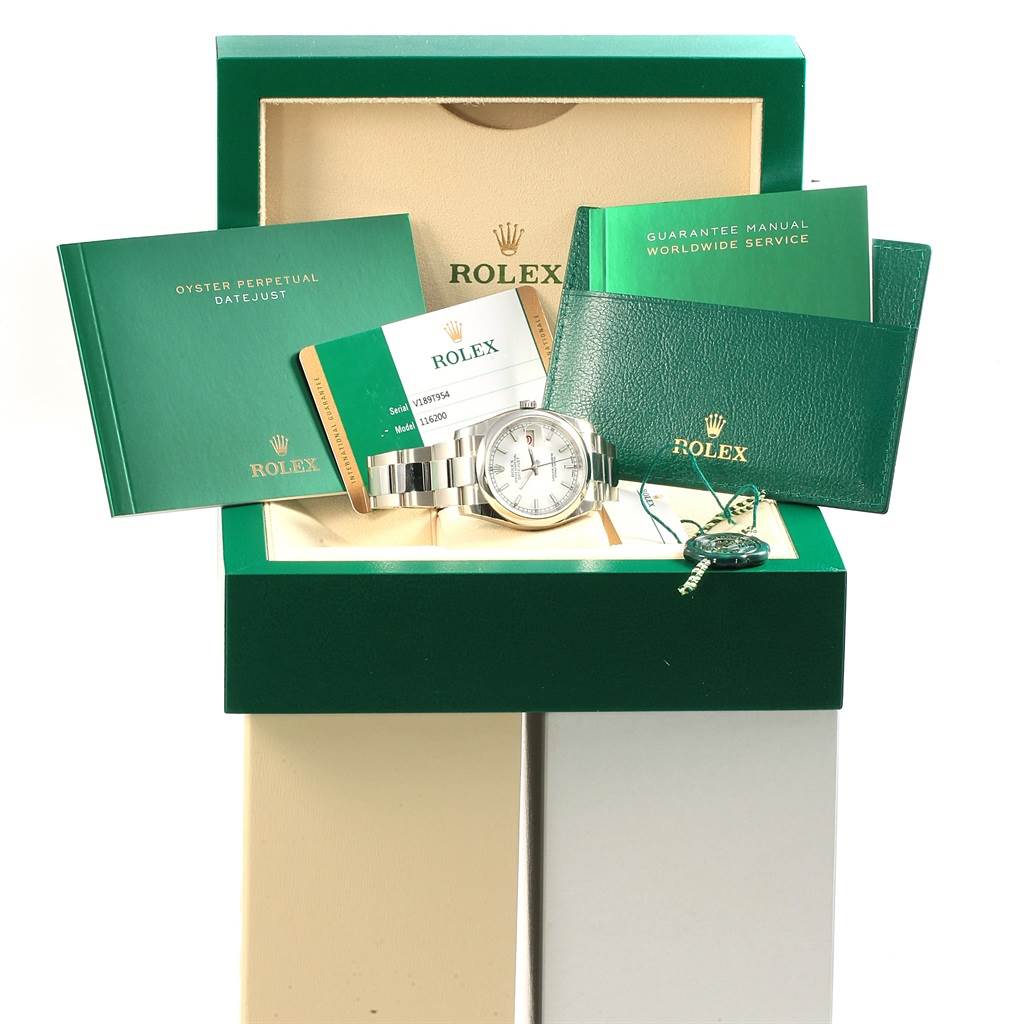 The image shows a Rolex Datejust 116200 Men's Stainless Steel White Dial 116200 Men's Stainless Steel White Dial watch with its box, manuals, service guarantee, and tag.