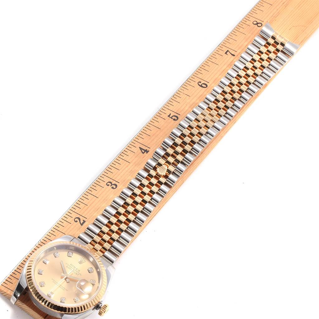 The Rolex Datejust 116233 Men's Stainless Steel Champagne Dial 116233 Men's Stainless Steel Champagne Dial watch is shown from an overhead angle, with the face and jubilee bracelet laid next to a ruler for measurement.