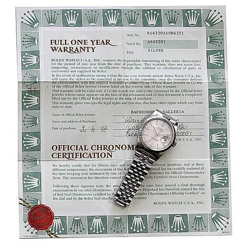 The image shows a silver Rolex Datejust 16220 Men's Stainless Steel Silver Dial 16220 Men's Stainless Steel Silver Dial watch placed on top of its warranty and certification papers.
