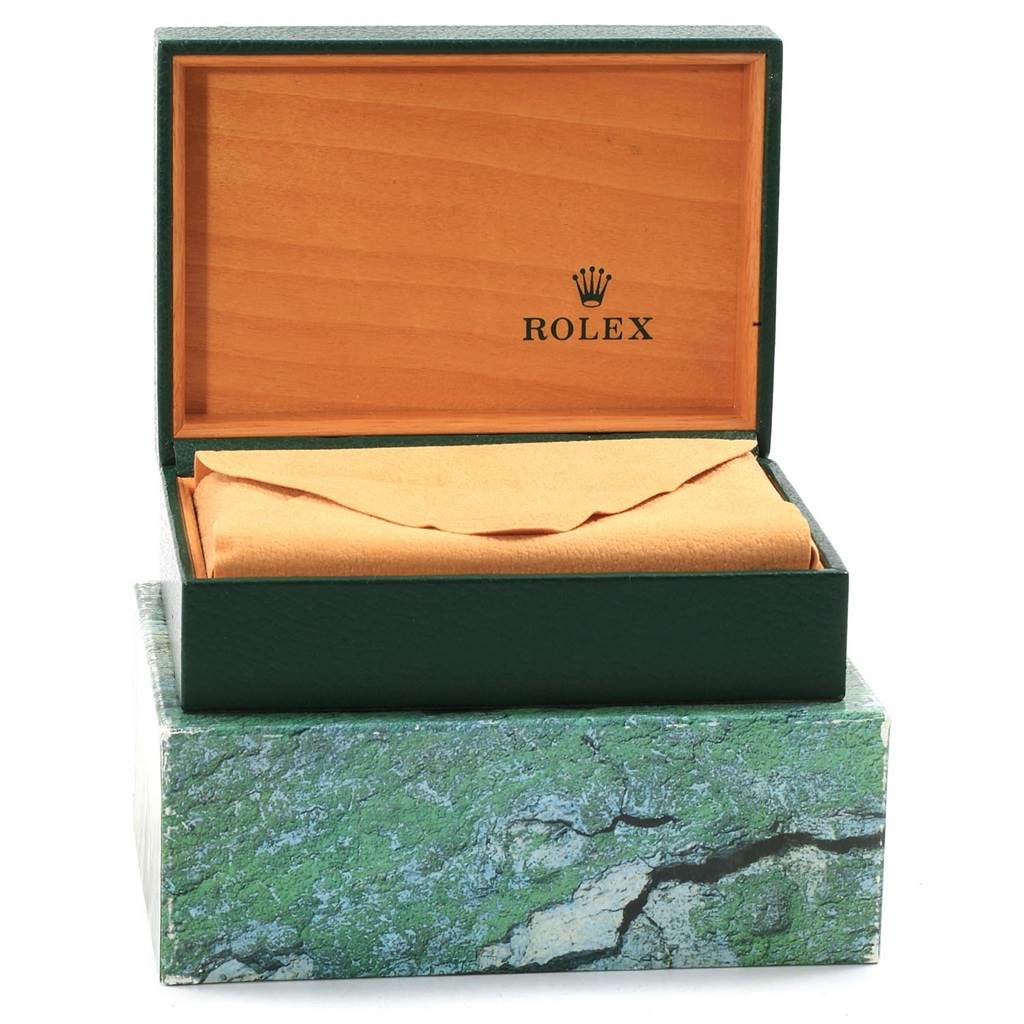 The image shows an open green and wood Rolex box, likely for a Datejust model, with a cloth covering the watch inside.