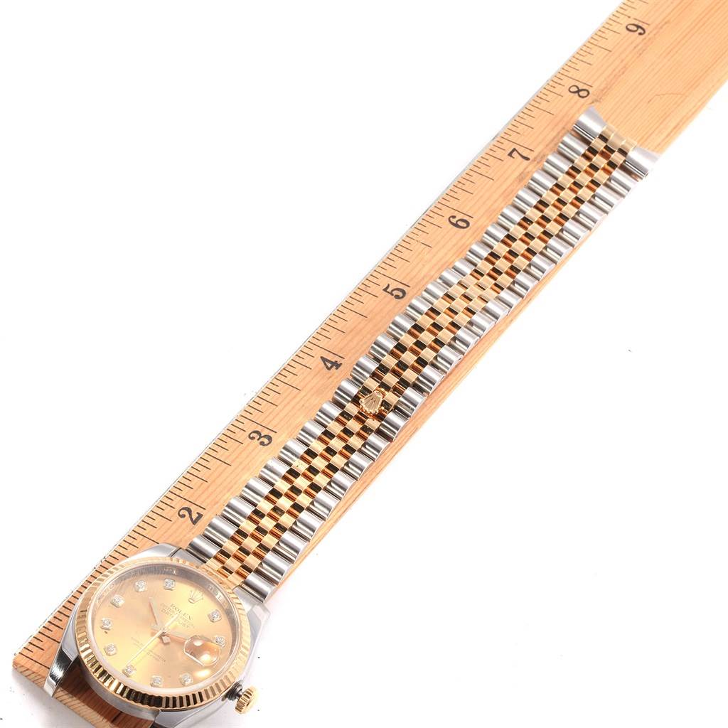 The image shows a head-on view of a Rolex Datejust 116233 Men's Stainless Steel Champagne Dial 116233 Men's Stainless Steel Champagne Dial watch and its jubilee bracelet measured against a ruler.