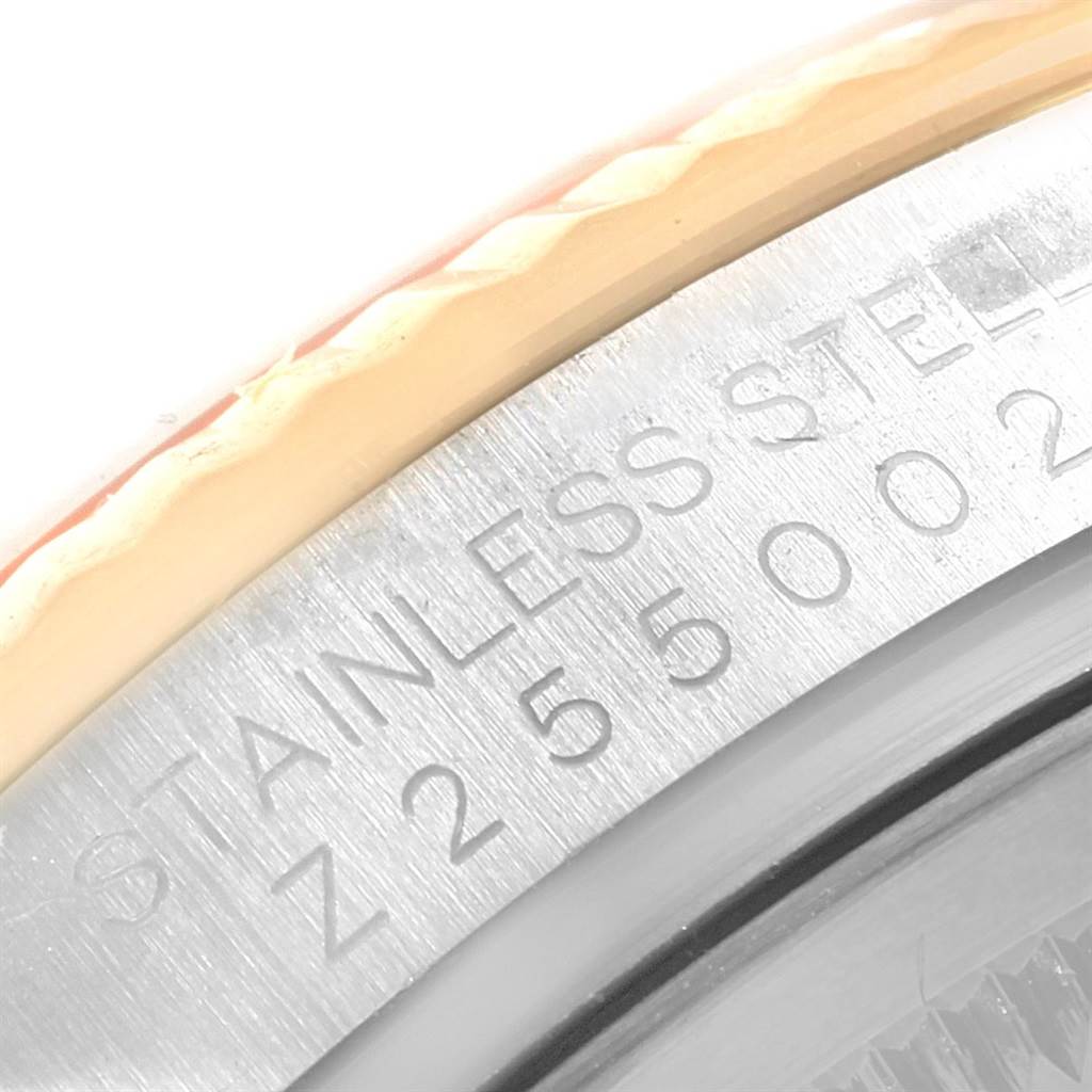 The image shows a close-up of the side of a Rolex Datejust 116233 Men's Stainless Steel Black Dial 116233 Men's Stainless Steel Black Dial watch, highlighting the fluted bezel and the engraved serial number.