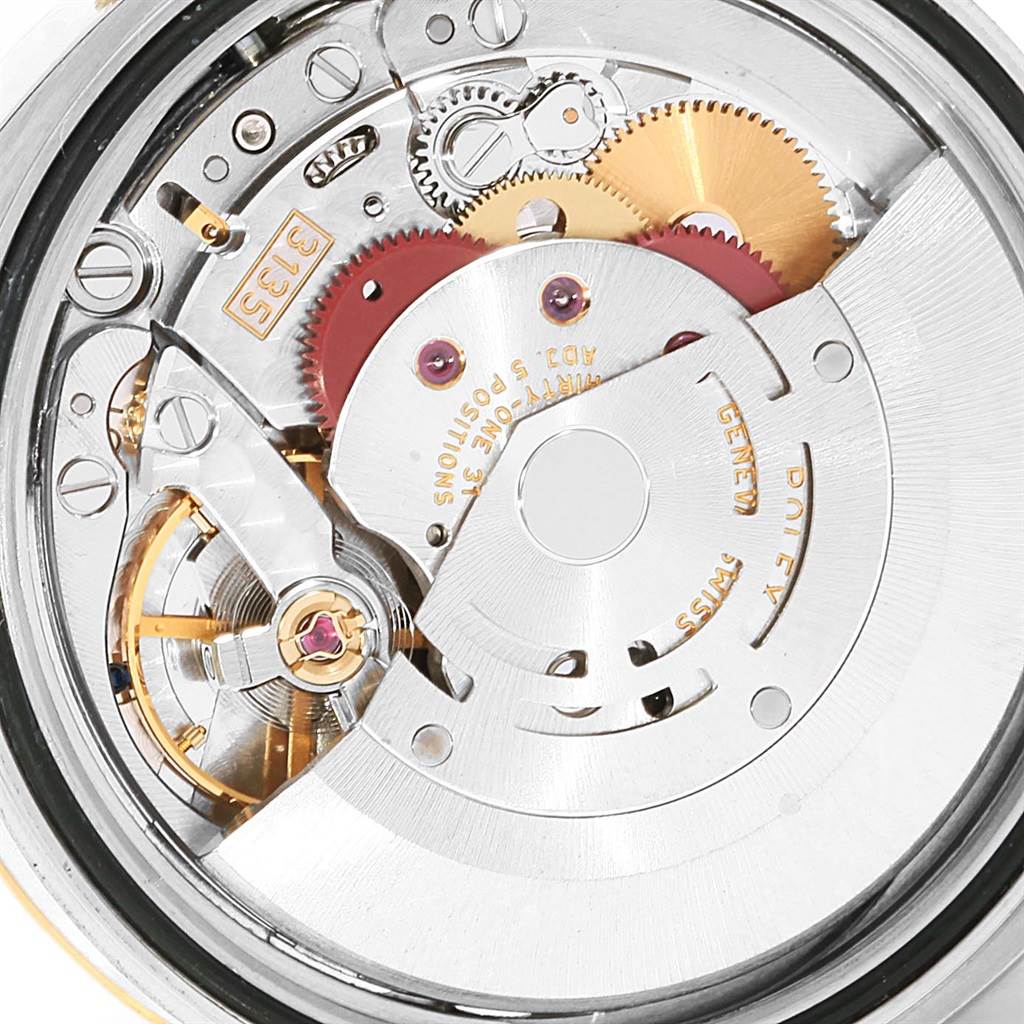 The image shows a detailed view of the inner mechanical movement of a Rolex Datejust 116233 Men's Stainless Steel Black Dial 116233 Men's Stainless Steel Black Dial watch with various gears and components.