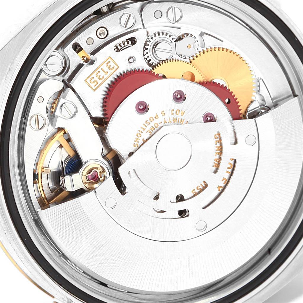 The image shows the internal movement mechanism of the Rolex Datejust 116233 Men's Stainless Steel White Dial 116233 Men's Stainless Steel White Dial watch, highlighting gears and the rotor from a bottom angle.