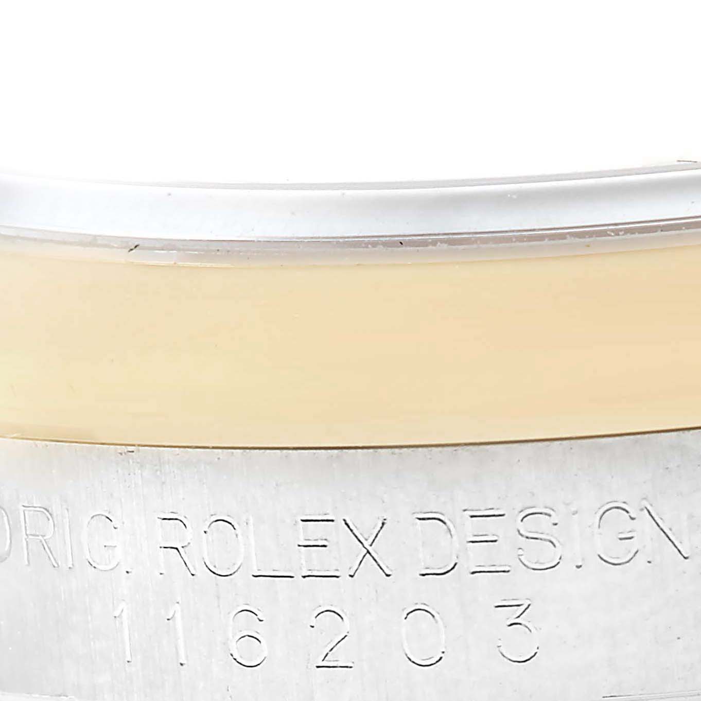This image shows a close-up of the Rolex Datejust 116203 Men's Stainless Steel Champagne Dial 116203 Men's Stainless Steel Champagne Dial watch's serial engraving and part of the watch's bezel.