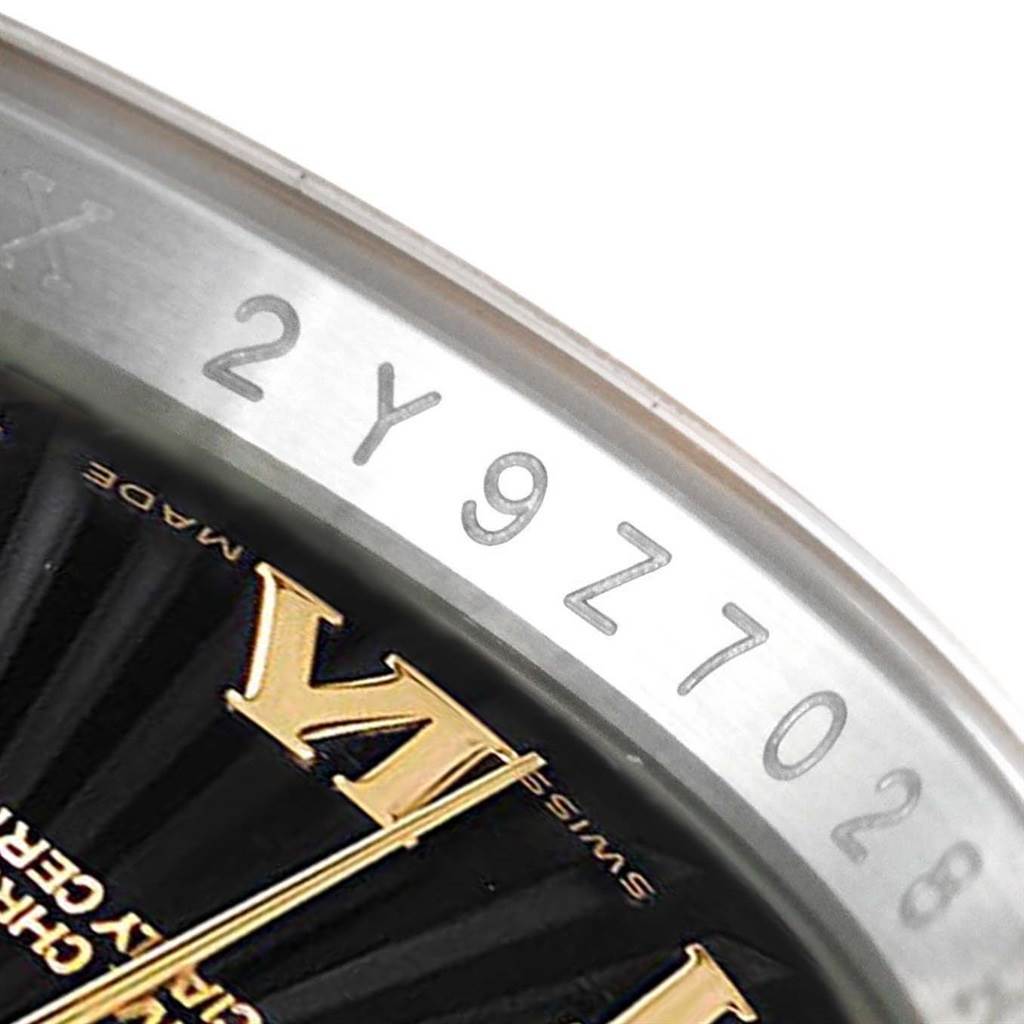 The image shows a partial view of the bezel and the dial of a Rolex Datejust 116203 Men
s Stainless Steel Black Dial 116203 Men
s Stainless Steel Black Dial watch, focusing on the serial number and part of the Roman numeral VI.