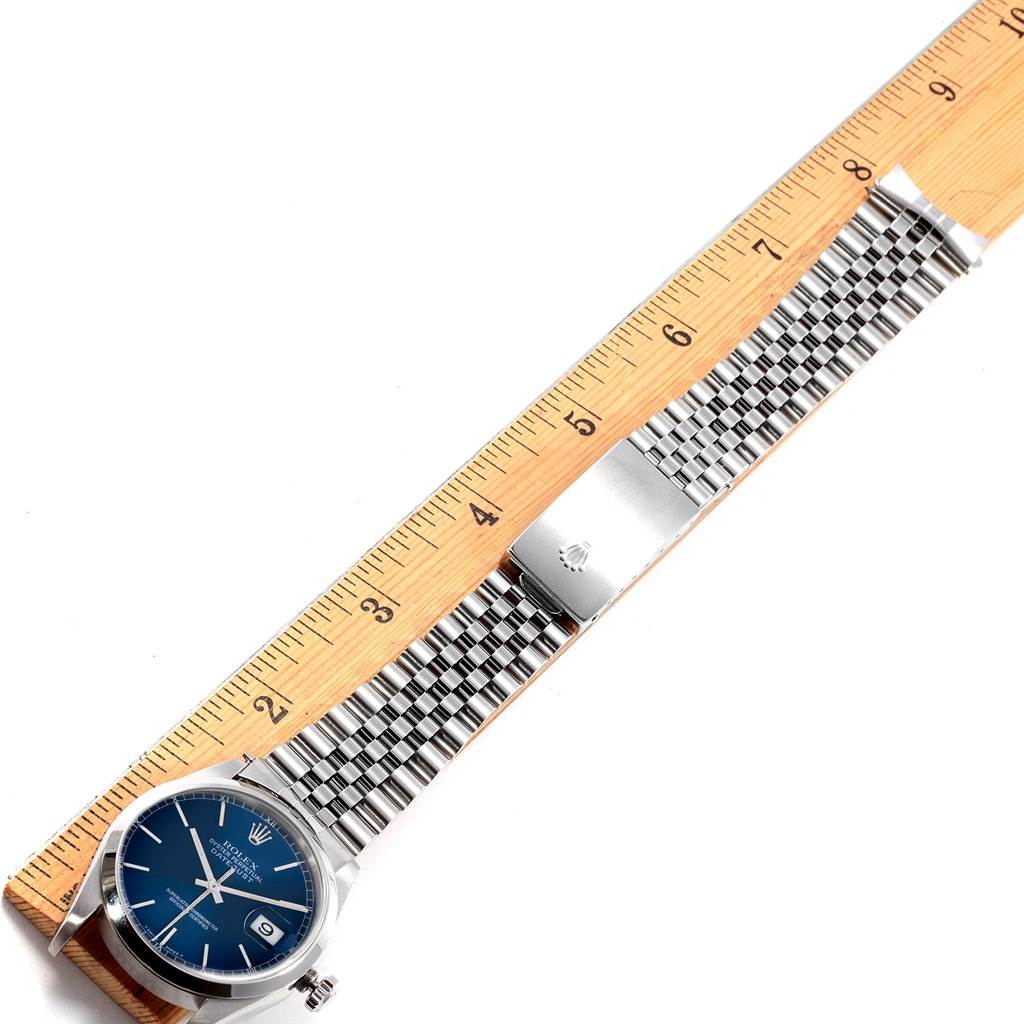 The Rolex Datejust 16200 Men's Stainless Steel Blue Dial 16200 Men's Stainless Steel Blue Dial watch is shown from a top view, displaying the face, bracelet, and clasp, measured against a ruler.